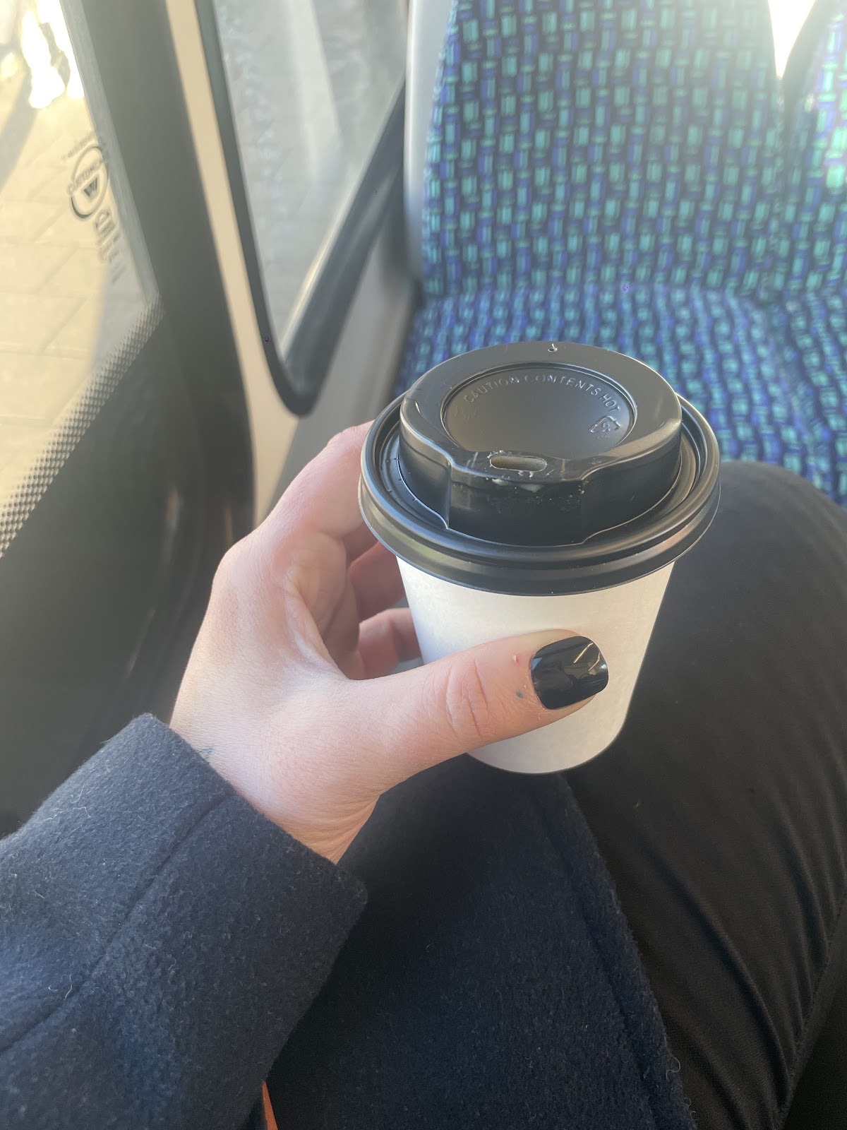 A lidded takeaway cup held on the way home
